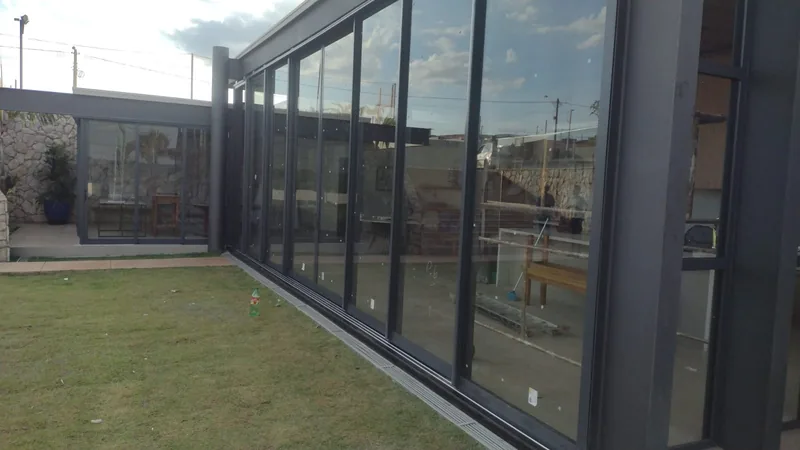 Sistema de correr panorâmico em alumínio preto executado pela Riberbond em residência de alto padrão